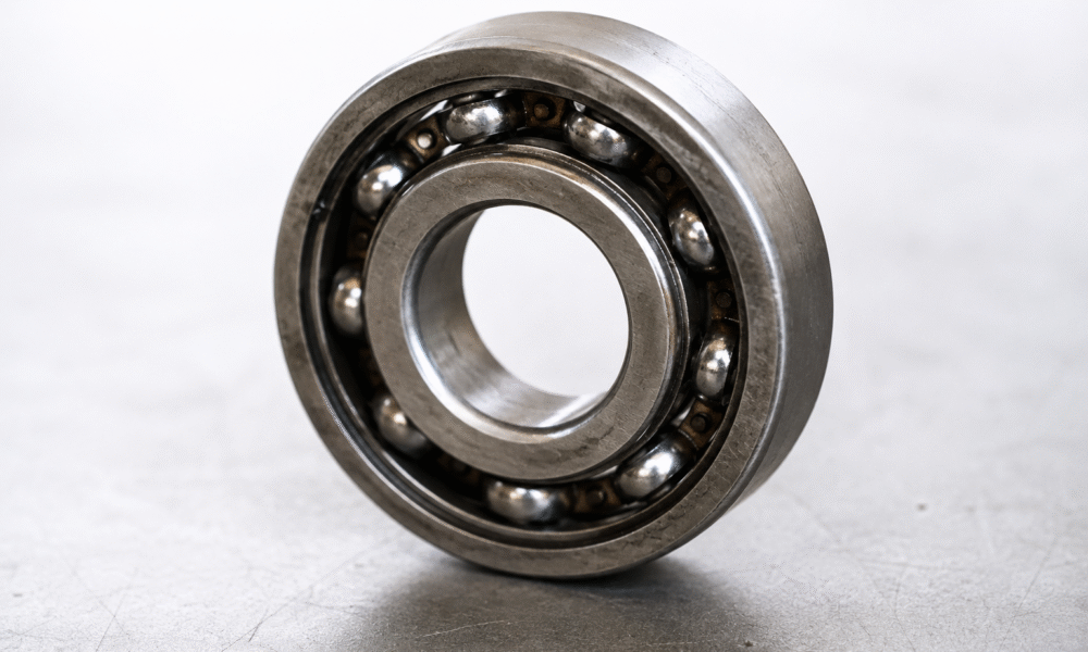 Close-up of an industrial ball bearing showing surface wear associated with fretting and pitting damage.