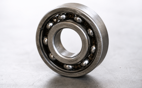 Close-up of an industrial ball bearing showing surface wear associated with fretting and pitting damage.
